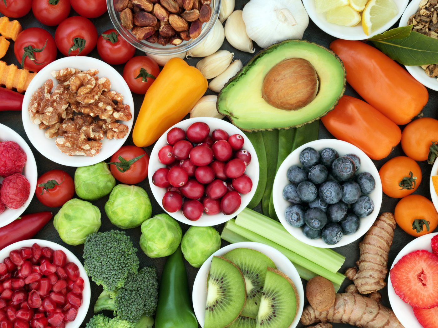 Fresh, colourful whole foods, tomatoes, avocado, berries and nuts